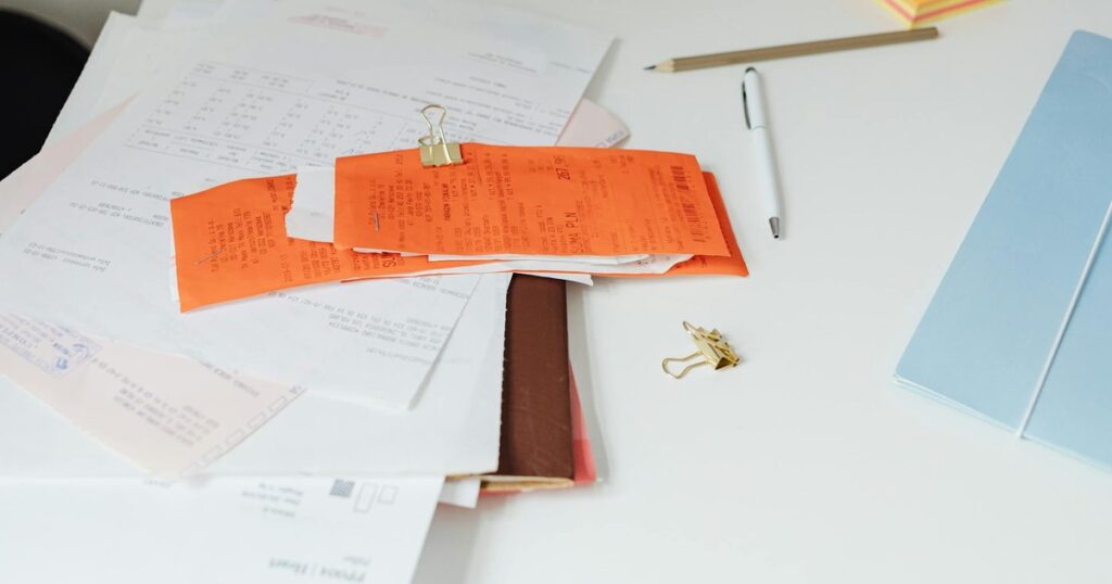 Escritorio con tickets y facturas en papel — la era pre-digital de la facturación que termina con Verifactu y la factura electrónica obligatoria