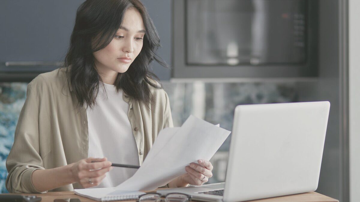 Responsable de una pequeña empresa revisando documentos y trabajando con el portátil
