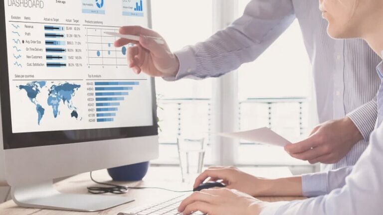 Dos personas revisando gráficos de métricas en la pantalla de un ordenador