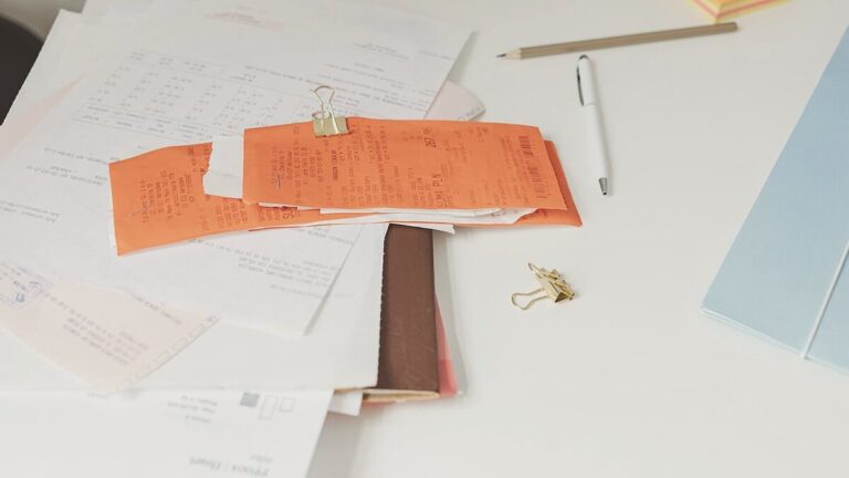 Escritorio con tickets y facturas en papel — la era pre-digital de la facturación que termina con Verifactu y la factura electrónica obligatoria