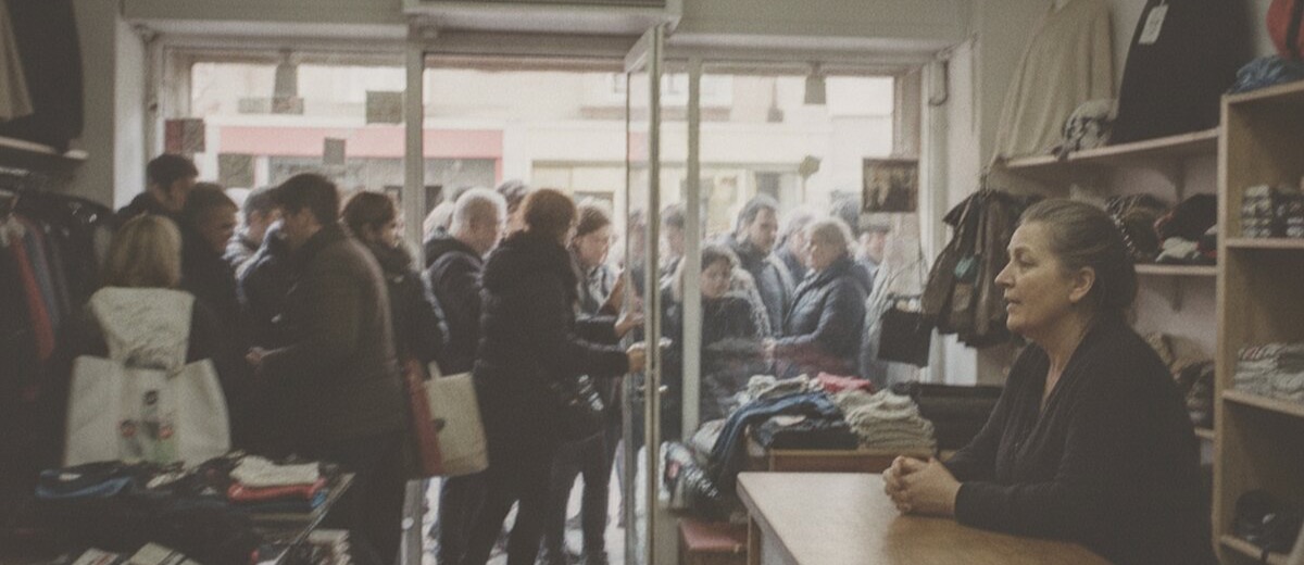 Clientes entrando en tropel por la puerta de una tienda de barrio